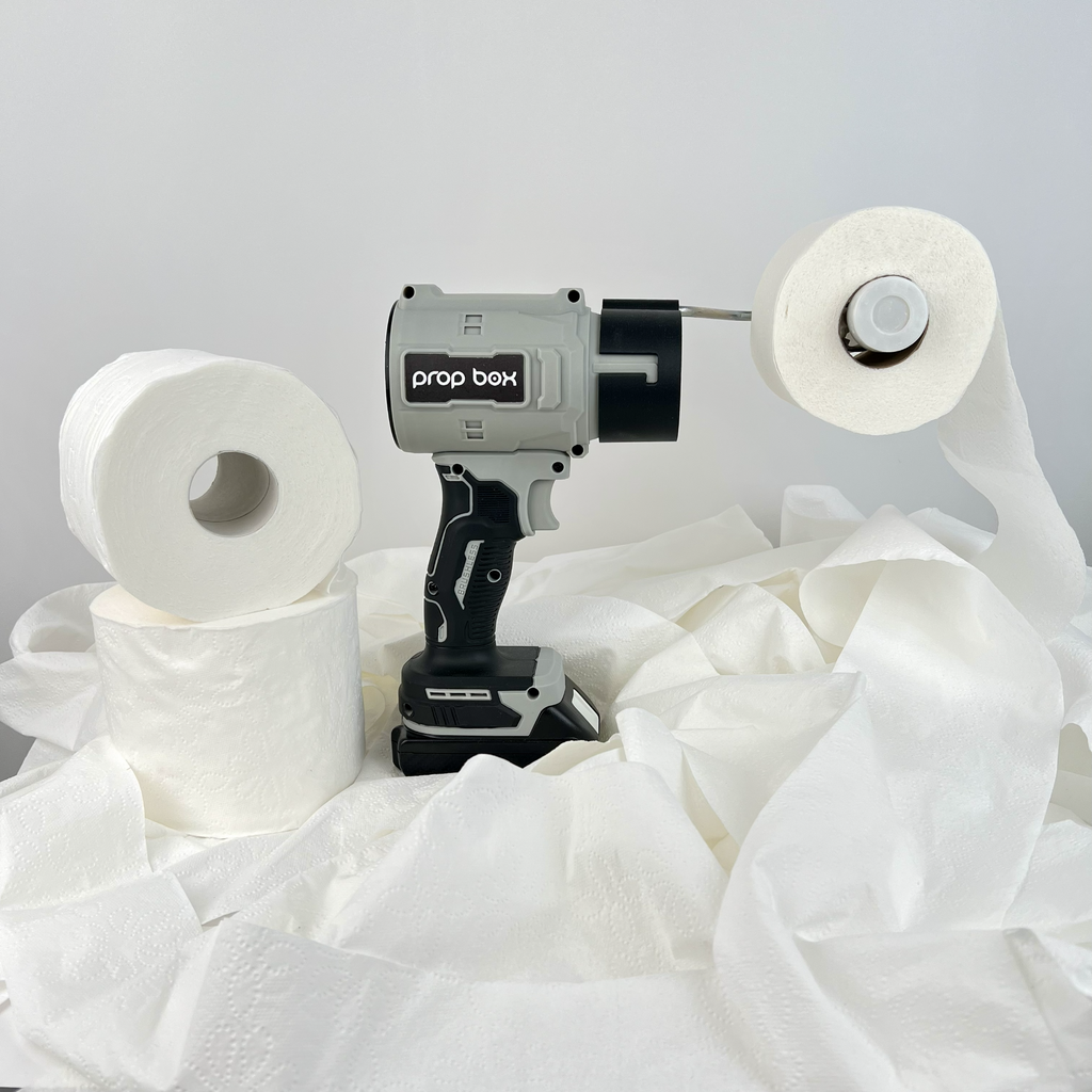Side view of mascot toilet paper blower prop sitting on extra rolls