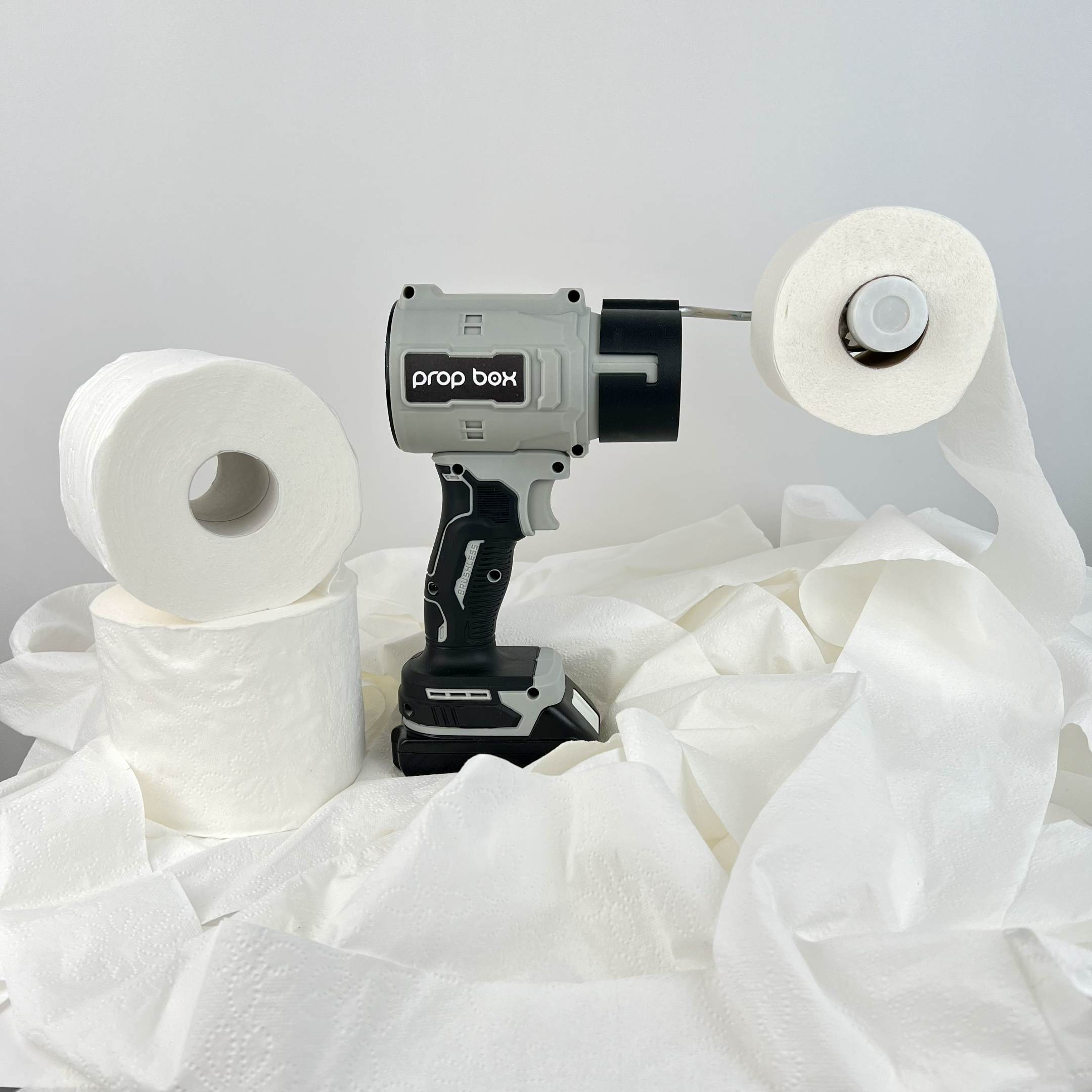Side view of mascot toilet paper blower prop sitting on extra rolls